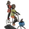 Statue of two children on a bicycle with a dog in a basket on a white background