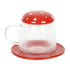 A glass mushroom-shaped mug with a red lid and a matching red saucer.
