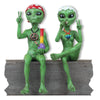 Two green alien figurines with peace signs and a rainbow object on a white background