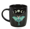 Black mug with a green butterfly moth design and moon phases on a white background