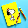 Yellow notebook with cartoon character and two pens on a blue background