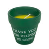 Green pot with a candle inside and 'Thank you for helping me grow' text on a white background