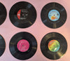 Four vinyl records coasters with colorful labels 