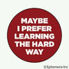 Red circle with white text 'MAYBE I PREFER LEARNING THE HARD WAY' on a white background