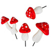 Set of red and white mushroom-shaped skewers with smiling faces on a white background