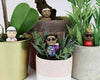 Small Hip Hop figurines in pots with plants on a white surface